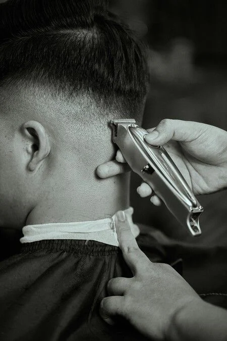 Barbero perfilando la nuca con máquina en Odry's Tamarindo