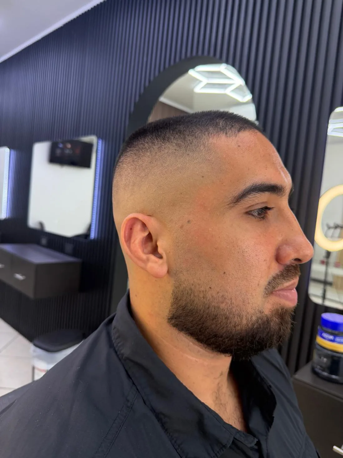 Fade alto con barba perfilada en el salón