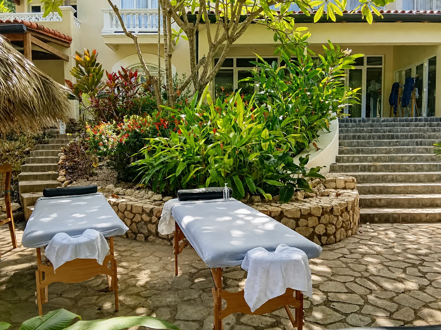 Camillas de masaje preparadas en el patio tropical de una villa